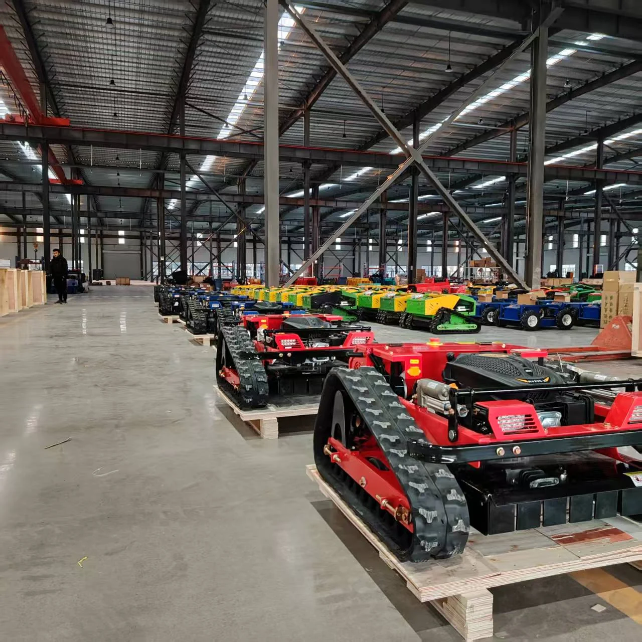 A palletized mower beside an open wooden crate in the factory yard.
