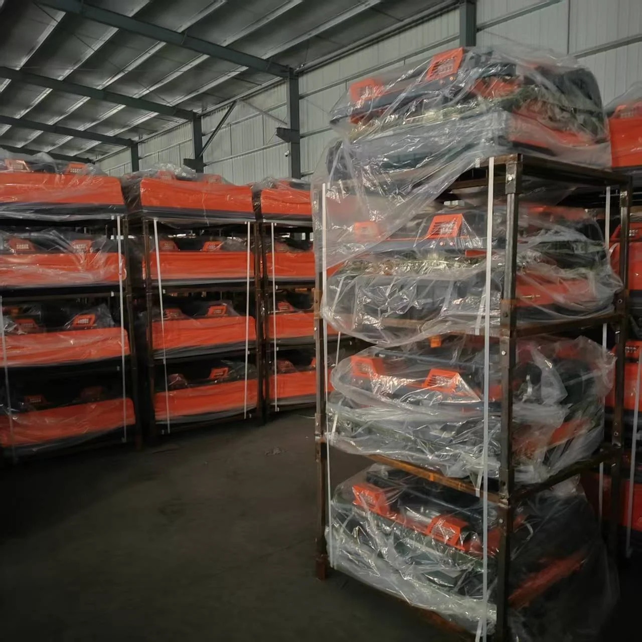 Machines protected with clear wrapping on workshop racks.